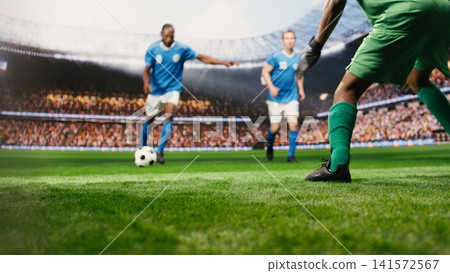 Selective focus of striker kicking ball in net for winning goal, shooting shot in front of goalkeeper during match action. Player in motion attacking net to score goal. Selective focus of striker kicking ball in net for winning goal, shooting shot in front of goalkeeper during match action. Player in motion attacking net to score goal. 141572567