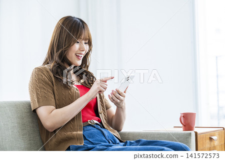 一個操作智能手機的年輕女子 141572573