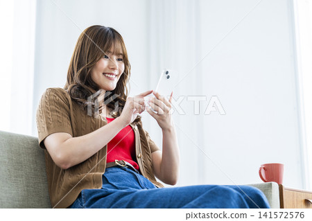 一個操作智能手機的年輕女子 141572576