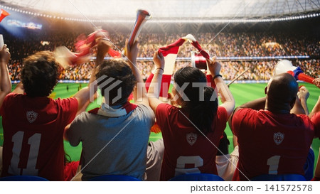 Happy woman has fun with football supporters in packed stadium during match day. Female soccer fan enjoys lively stadium atmosphere among friends in cheering crowd Happy woman has fun with football supporters in packed stadium during match day. Female soccer fan enjoys lively stadium atmosphere among friends in cheering crowd 141572578