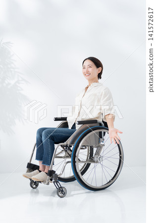 A woman riding a wheelchair A woman riding a wheelchair 141572617