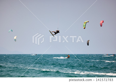 Kitesurfer performs a high Big Air jump over the sea in Nha Trang, Vietnam Kitesurfer performs a high Big Air jump over the sea in Nha Trang, Vietnam 141572783