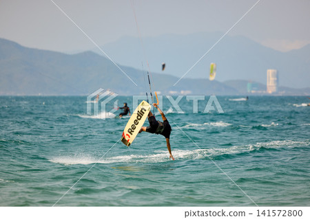 Kitesurfer Performing One Handed Water Drag Turn Kitesurfer Performing One Handed Water Drag Turn 141572800