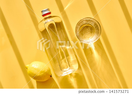 Refreshing water with lemon in bottle and glass Refreshing water with lemon in bottle and glass 141573271