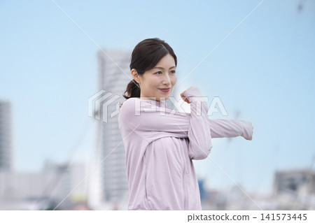 中年婦女身穿運動服伸展身體 中年婦女身穿運動服伸展身體 141573445