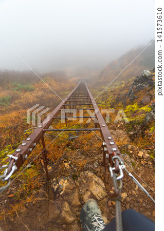 Enduring strong winds and dense fog, we made our way up the Genji Ladder on Mt. Gongen in the Southern Yatsugatake Mountains. Enduring strong winds and dense fog, we made our way up the Genji Ladder on Mt. Gongen in the Southern Yatsugatake Mountains. 141573610
