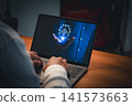 Person typing on laptop displaying a glowing blue hologram of a hand holding a shield with cryptocurrency symbol. Concept of blockchain security, safe digital investment and crypto wallet. 141573663