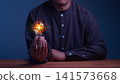 Man holding a glowing light bulb with a brain inside. This concept illustrates artificial intelligence, smart business innovation, human creativity, technology, and brilliant mind ideas. 141573668