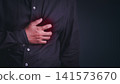 A grown man clutches his chest in agony during a severe heart attack, illustrating a critical cardiovascular and medical emergency. 141573670
