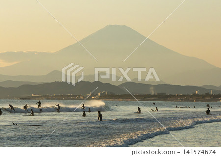 Shonan Kugenuma Beach: Mount Fuji and the silhouettes of surfers at sunset. Shonan Kugenuma Beach: Mount Fuji and the silhouettes of surfers at sunset. 141574674