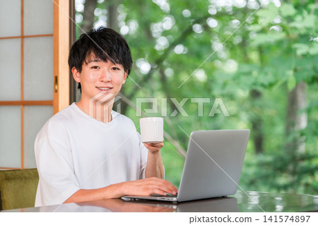 一位自由工作者在工作休假/遠距工作之餘，正在休息時喝咖啡。 141574897