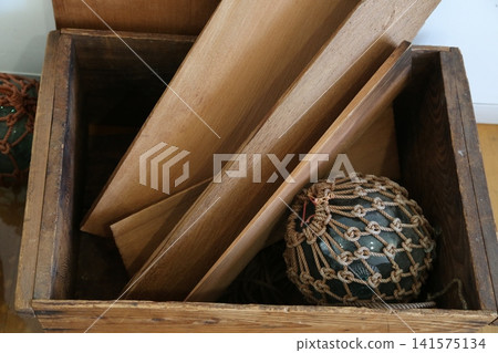 Glass floats and rope in a wooden box Glass floats and rope in a wooden box 141575134
