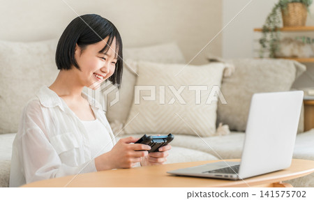 Middle school and high school girls playing online games and video games in the living room. Middle school and high school girls playing online games and video games in the living room. 141575702