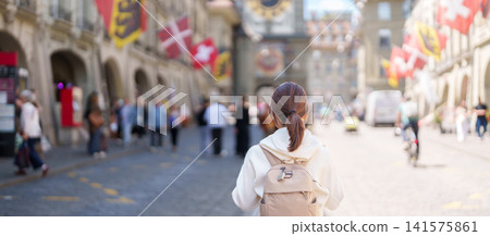 Woman Tourist Exploring Bern, Switzerland. Traveler Visit Kramgasse, Bern Old Town and the Zytglogge Clock Tower, Famous European Landmark, Popular Tourist Attraction and Travel Destination in Europe Woman Tourist Exploring Bern, Switzerland. Traveler Visit Kramgasse, Bern Old Town and the Zytglogge Clock Tower, Famous European Landmark, Popular Tourist Attraction and Travel Destination in Europe 141575861