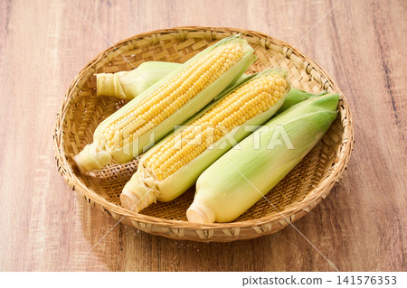 玉米:帶皮的生玉米,裝在竹籃裡。 玉米:帶皮的生玉米,裝在竹籃裡。 141576353