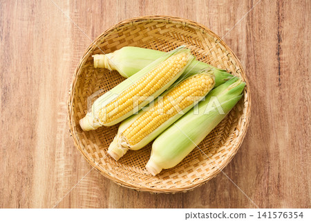 玉米:帶皮的生玉米,裝在竹籃裡。 玉米:帶皮的生玉米,裝在竹籃裡。 141576354