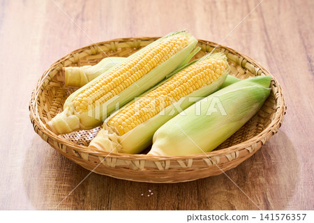 玉米:帶皮的生玉米,裝在竹籃裡。 玉米:帶皮的生玉米,裝在竹籃裡。 141576357