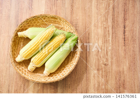 玉米：帶皮的生玉米，裝在竹籃裡。 141576361