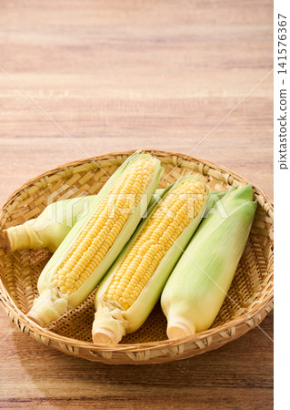玉米：帶皮的生玉米，裝在竹籃裡。 141576367