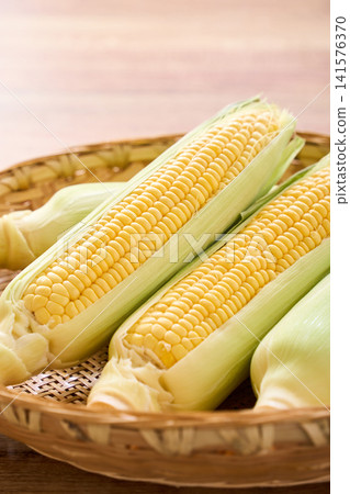 Corn: Raw corn with the husks still on, served in a bamboo basket. Corn: Raw corn with the husks still on, served in a bamboo basket. 141576370