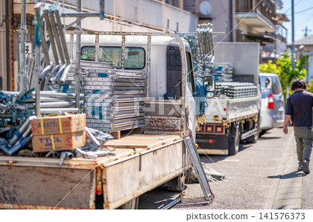 Construction site, scaffolding, delivery of scaffolding planks, workers, delivery, truck 141576373