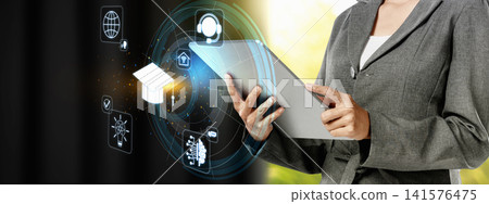 A professional woman in a suit holds a digital tablet displaying holographic icons of education, technology, and global communication, representing modern learning. Concept of e-learning A professional woman in a suit holds a digital tablet displaying holographic icons of education, technology, and global communication, representing modern learning. Concept of e-learning 141576475