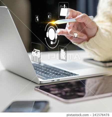 A person uses a stylus to select a digital headset icon for online medical support on a laptop, symbolizing telehealth customer service. Telehealth and online medical consultation concept A person uses a stylus to select a digital headset icon for online medical support on a laptop, symbolizing telehealth customer service. Telehealth and online medical consultation concept 141576478