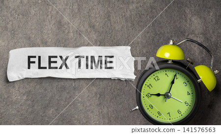 Close-up shot of an analog alarm clock with a neon green face next to a piece of paper with the words FLEX TIME, set against a textured grey background, symbolizing flexible work. Concept of Flextime Close-up shot of an analog alarm clock with a neon green face next to a piece of paper with the words FLEX TIME, set against a textured grey background, symbolizing flexible work. Concept of Flextime 141576563
