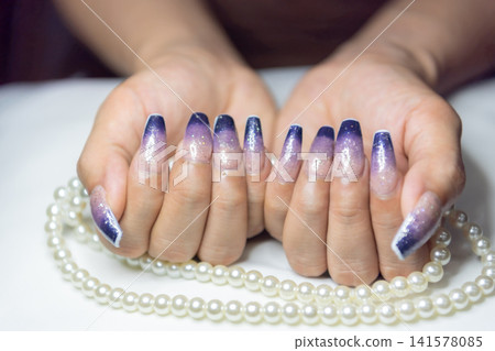 Elegant hands purple ombre glitter manicure featuring long acrylic nails showcasing modern nail fashion beauty salon craftsmanship luxury style feminine elegance 141578085
