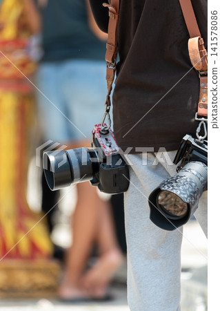 Professional photographer carrying two cameras telephoto lenses ready to capture events wildlife travel documentary moments using advanced photography equipment 141578086