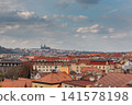 Historic Prague Rooftops with Prague Castle Beneath Dramatic Spring Clouds at Sunset 141578198