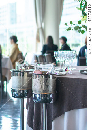 Wine and wine glasses placed in the center of the restaurant, along with a wine cooler. 141578410