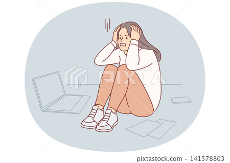 Upset cold woman suffering from stress or burnout, sitting on floor near papers and laptop Upset cold woman suffering from stress or burnout, sitting on floor near papers and laptop 141578803