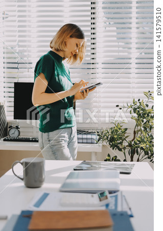 Closeup image of a businesswoman using mobile phone in office Closeup image of a businesswoman using mobile phone in office 141579510