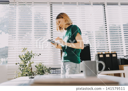 Closeup image of a businesswoman using mobile phone in office Closeup image of a businesswoman using mobile phone in office 141579511