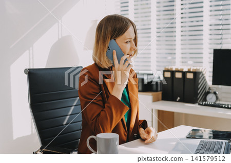Woman smiling to herself as she works in an office 141579512