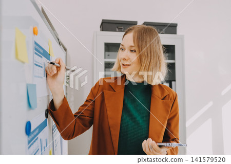 Woman smiling to herself as she works in an office Woman smiling to herself as she works in an office 141579520