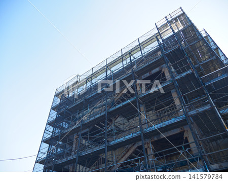 Temporary fences and scaffolding at a building construction site Temporary fences and scaffolding at a building construction site 141579784