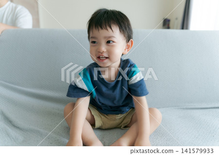 Close-up of a boy sitting on a sofa Close-up of a boy sitting on a sofa 141579933