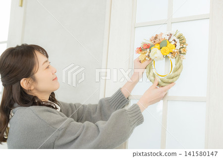 A smiling woman holding a Shimenawa wreath A smiling woman holding a Shimenawa wreath 141580147