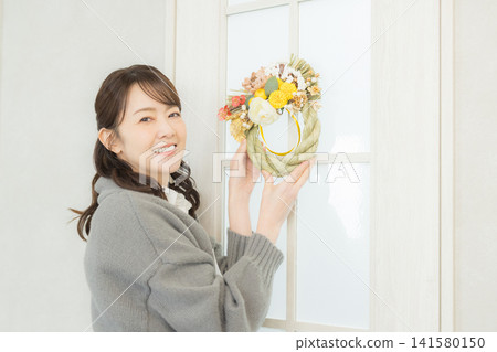 一位微笑的女子手捧注連繩花環。 一位微笑的女子手捧注連繩花環。 141580150