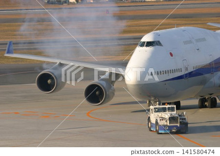 A B747 being pushed back by a towing vehicle. A B747 being pushed back by a towing vehicle. 141580474