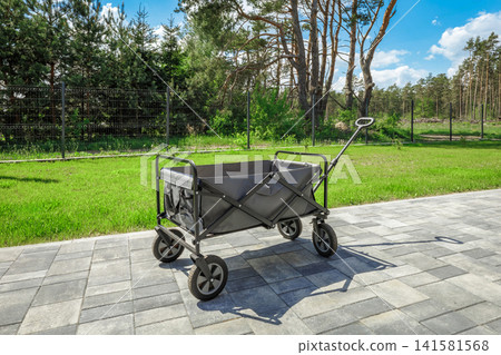 Foldable Utility Wagon Cart Outdoors on Paved Pathway Foldable Utility Wagon Cart Outdoors on Paved Pathway 141581568