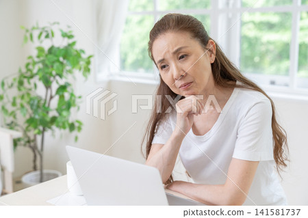 Senior women think about using computers. Senior women think about using computers. 141581737
