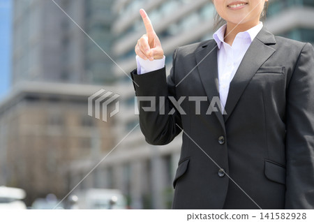 A Japanese woman in her 20s working in an office points her finger. A Japanese woman in her 20s working in an office points her finger. 141582928