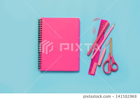 Pink girlish school supplies, notebooks and pens on punchy blue. Pink girlish school supplies, notebooks and pens on punchy blue. 141582968