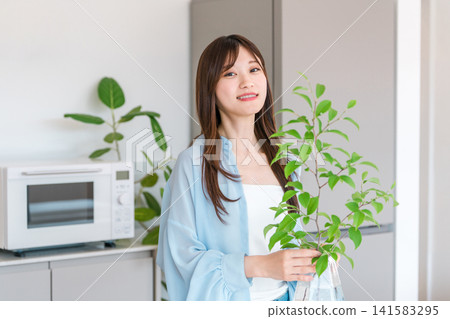 花瓶，年輕女子把植物放在花瓶裡 141583295