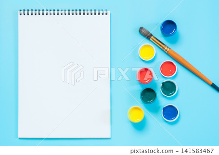 Back to school. Colorful paints, album and brush on punchy blue. Back to school. Colorful paints, album and brush on punchy blue. 141583467