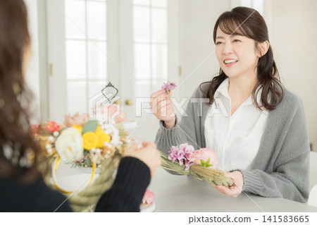 一位微笑的女子手捧注連繩花環。 一位微笑的女子手捧注連繩花環。 141583665