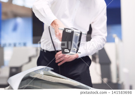Metrology engineer performing quality control or inspection with handheld professional 3D laser scanner Metrology engineer performing quality control or inspection with handheld professional 3D laser scanner 141583698